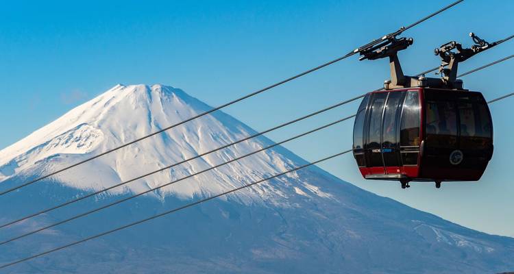 Téléphérique avec le mont Fuji en arrière-plan par une journée claire.