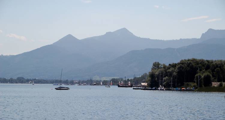 Lac avec voilier et toile de fond montagneuse.