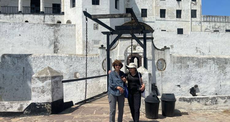 Two tourists standing in front of an old building.