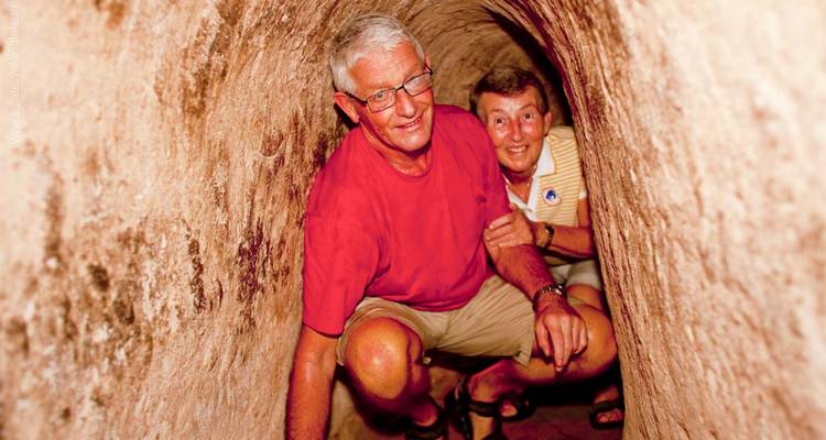 Deux personnes accroupies à l'intérieur d'un tunnel étroit.