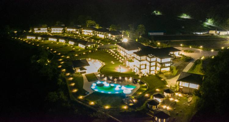 Complejo turístico tenuemente iluminado de noche visto desde arriba.