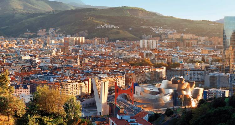 Stadtansicht mit einzigartiger moderner Architektur und umgebenden Hügeln.