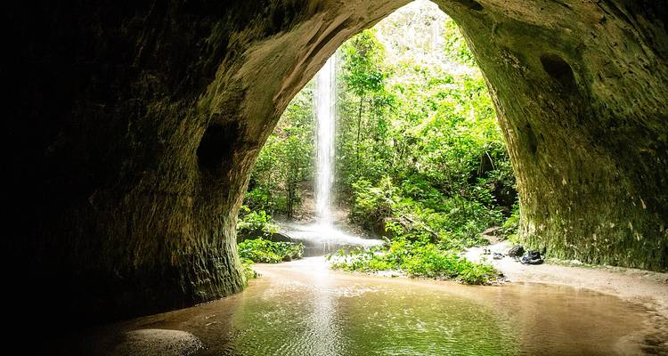 Cascade coulant d'une arche rocheuse naturelle dans une zone de jungle.