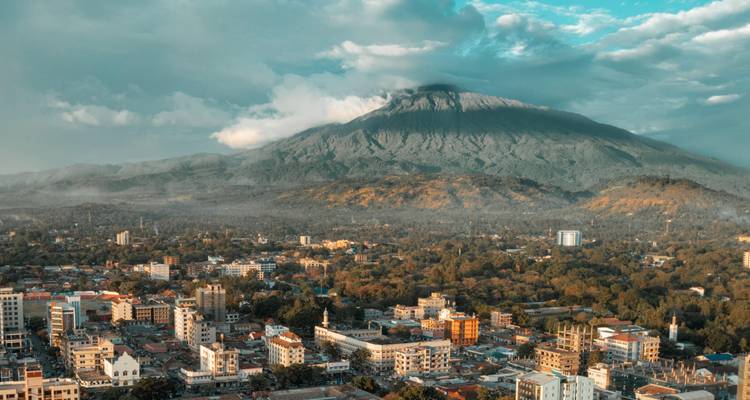 Paisaje urbano with una montaña en el fondo bajo un cielo nublado.