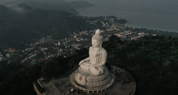 Vue aérienne d'une grande statue de Bouddha surplombant la ville.