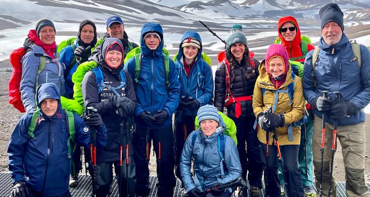 Group of hikers in colorful jackets on a snowy landscape.
