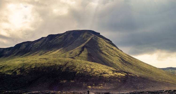 Montagne verte avec ombre dramatique et lumière du soleil.