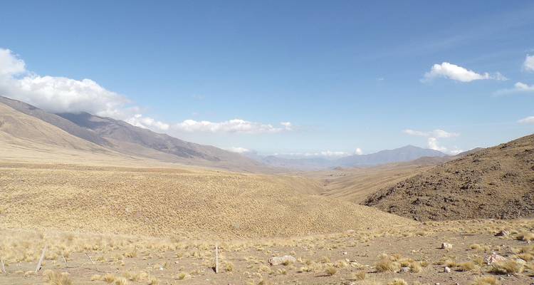 Droog landschap met heuvels onder een heldere hemel.