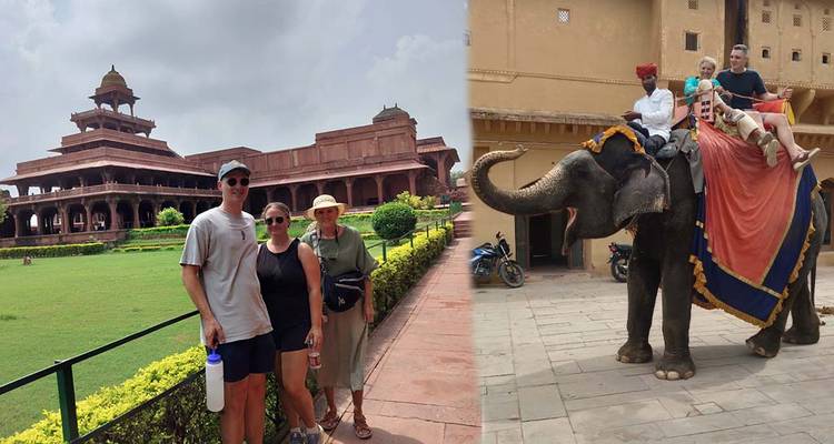 People standing in front of a red sandstone structure and riding an elephant.