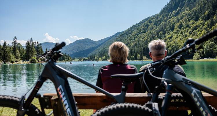 Couple sitting by a lake with bicycles in the foreground.