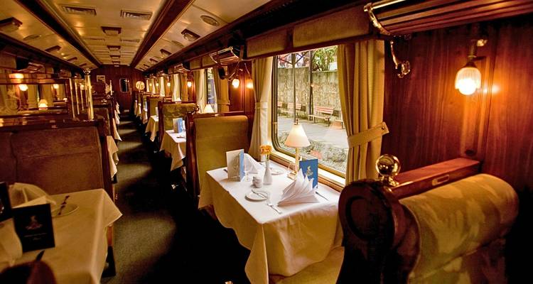 Luxuriöser Speisewagen eines Zuges mit eleganten Dekorationen.
