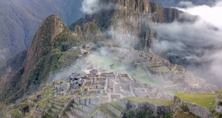 Neblige Aussicht auf Machu Picchu mit teilweiser Wolkenbedeckung.