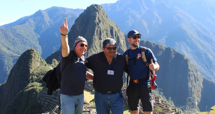 Drei Männer posieren bei Machu Picchu vor einer malerischen Kulisse.