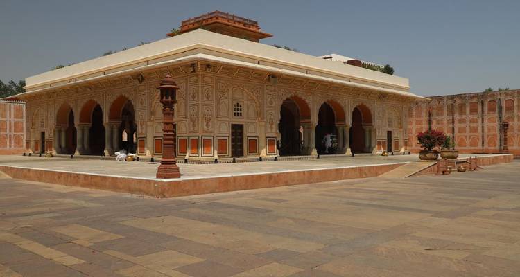 Interior courtyard of a palace featuring arched windows and a clear sky.
