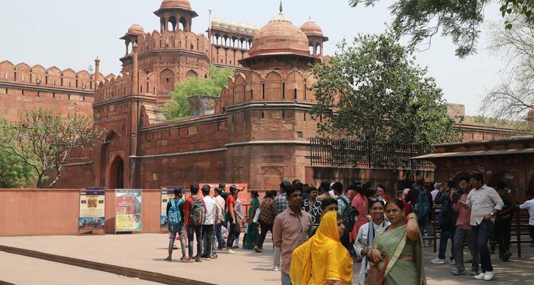 Tourists gathered at the entrance of a large historic fort.