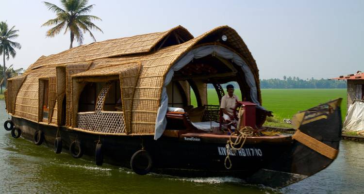 Traditional houseboat navigating the backwaters.