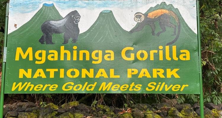 Sign for Mgahinga Gorilla National Park with a mountain backdrop.
