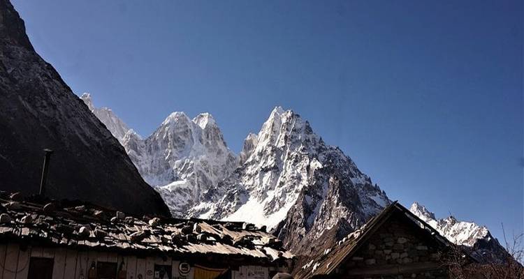 Sommets de montagnes en arrière-plan de bâtiments ruraux.