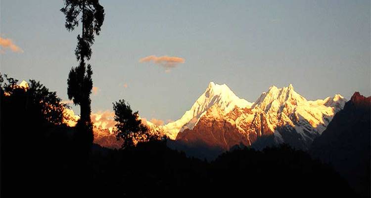 Vue du coucher de soleil sur une chaîne de montagnes.