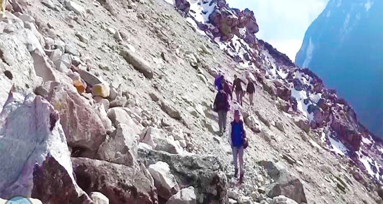 Randonneurs sur un sentier de montagne rocheux.