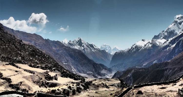 Vue panoramique de montagnes enneigées sous un ciel dégagé.