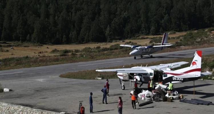 Petits avions sur une piste d'atterrissage entourée d'un terrain montagneux.
