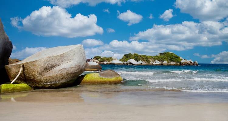 Sonniger tropischer Strand mit riesigen Granitfelsen, weißem Sand und türkisfarbenen Wellen