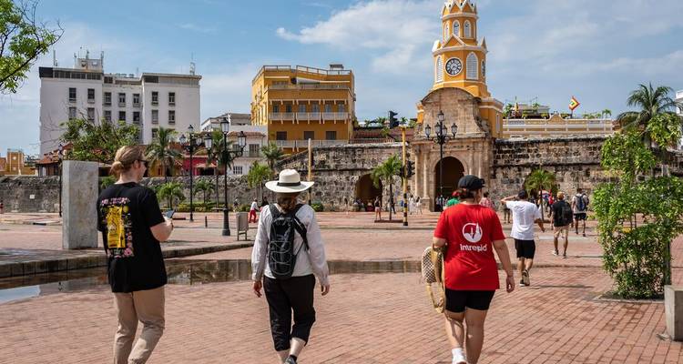 Reisegruppe, die an einem sonnigen Morgen zum gelben Uhrmturmtor von Cartagena läuft.
