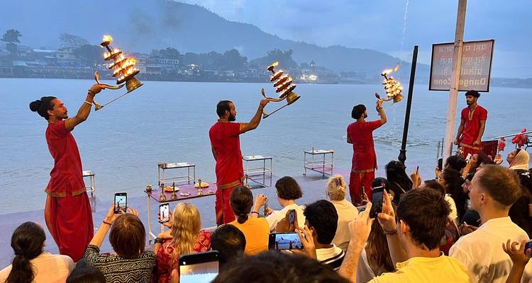 Religious ceremony beside the river with people holding offerings.