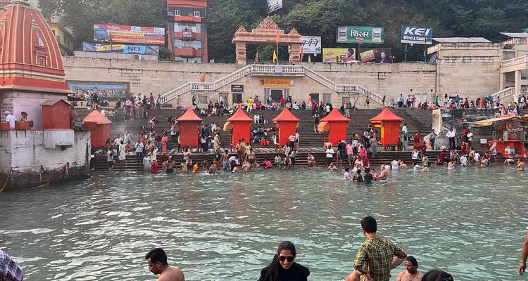 People gathered at the ghats of a river in a temple area.