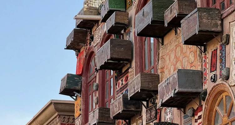 Close-up of a building facade with various wooden box structures attached.
