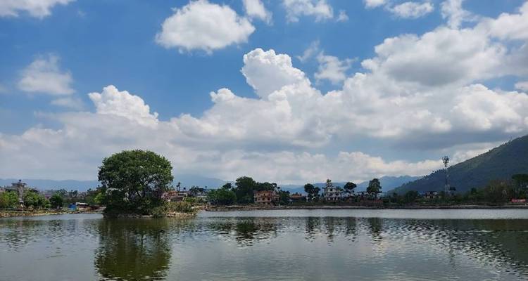 Vue paisible d'un lac avec reflets et ciel dégagé.