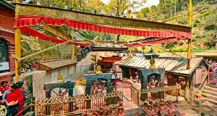 Temple traditionnel entouré par la nature avec des visiteurs.