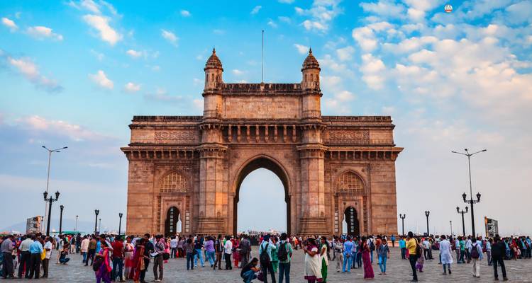 La Porte de l'Inde avec une foule rassemblée autour, sous un ciel bleu.