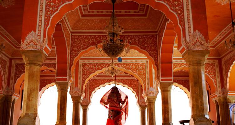Intérieur d'architecture indienne traditionnelle avec une femme en tenue traditionnelle.