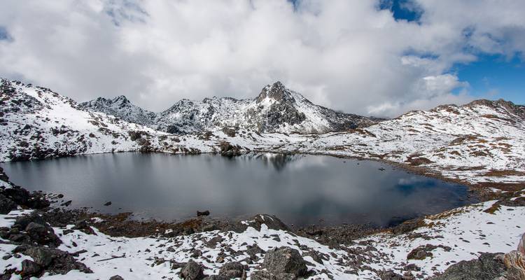 Malerischer Blick auf einen See, umgeben von schneebedeckten Bergen.