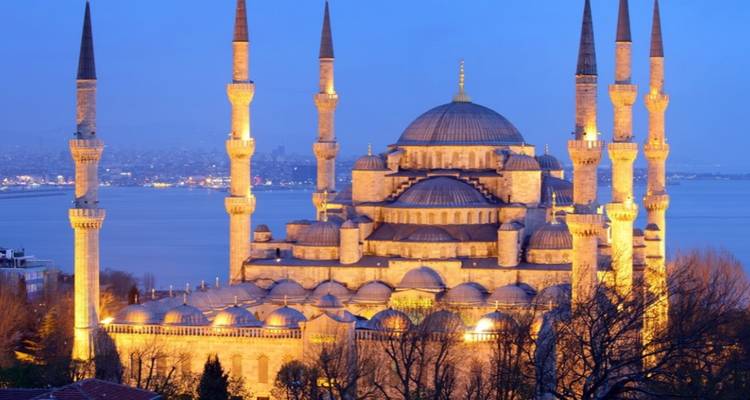 Famous historic mosque with a sea in the background at dusk.