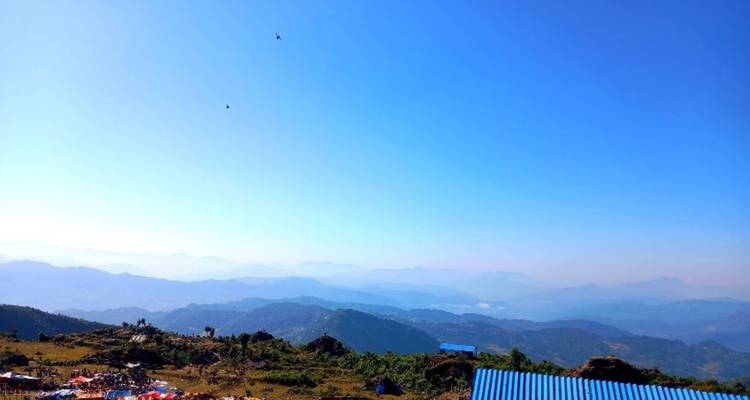 Uitgestrekt landschap met verre bergen onder een heldere blauwe hemel.