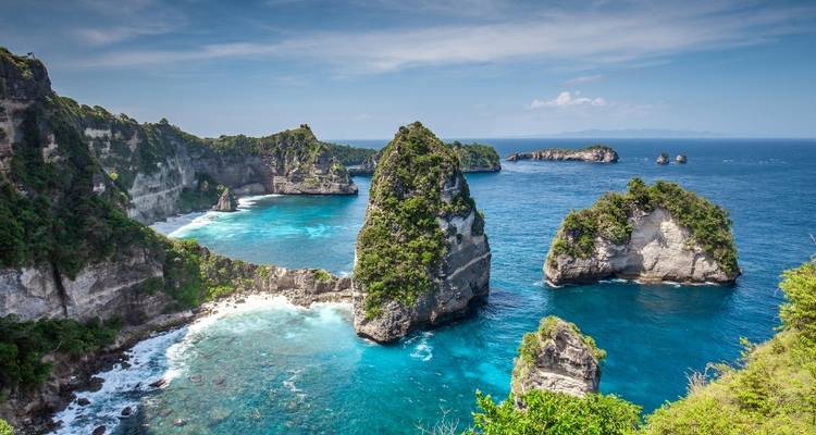 Weelderig kustlandschap met helder blauw water.