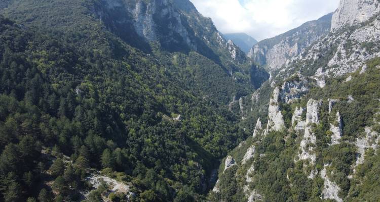 Scenic view of a lush green mountain valley with dramatic cliffs.