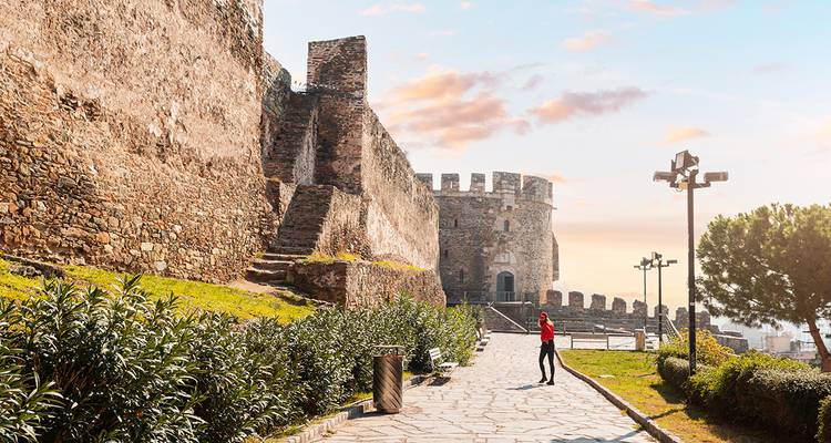 A person walking near historical city walls during sunset, Thessaloniki, Greece.
