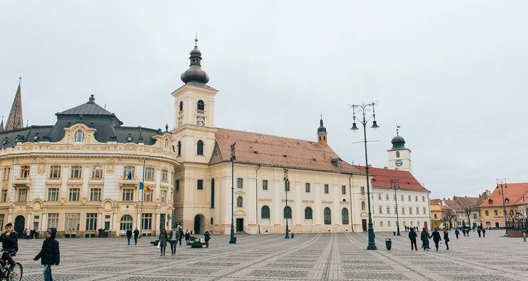 The large baroque buildings of Sibiu’s Great Square overlook cobbled patterns with locals and visitors strolling.