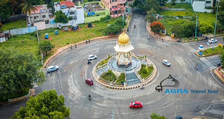 Vue aérienne d'un rond-point dans une zone urbaine avec un monument central.