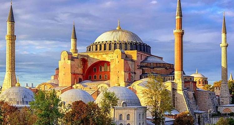 Historische Moschee mit Kuppeln und Minaretten bei Sonnenuntergang.