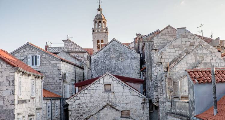 Old town with stone buildings and a tower.