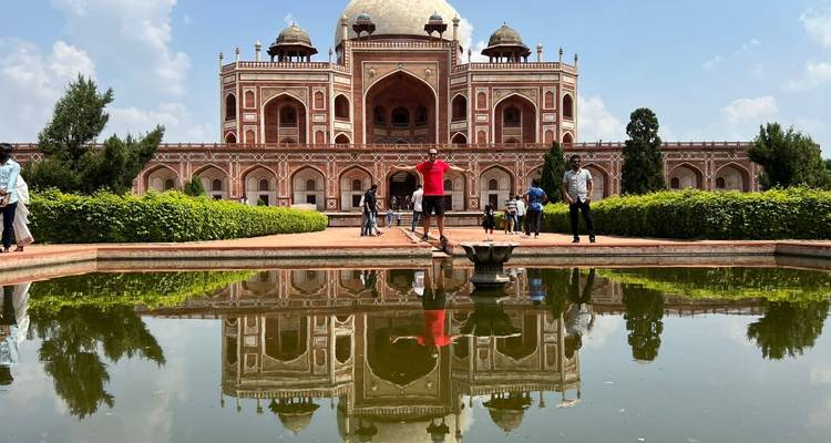 Estanque reflectante frente a la Tumba de Humayun con personas alrededor.