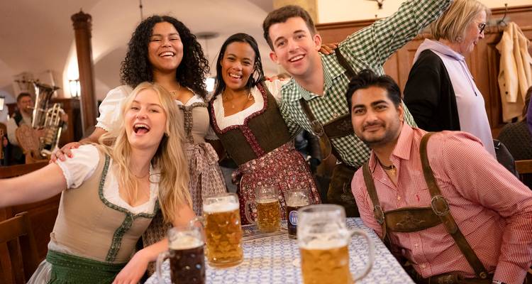 Groupe d'amis en tenues traditionnelles savourant de la bière lors d'une fête.
