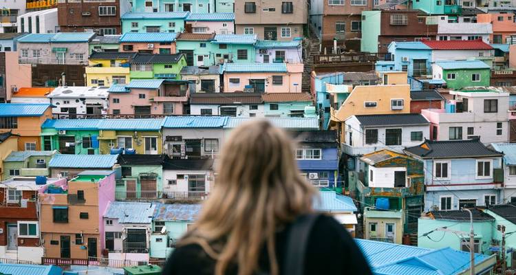 Femme regardant des maisons colorées sur une colline.