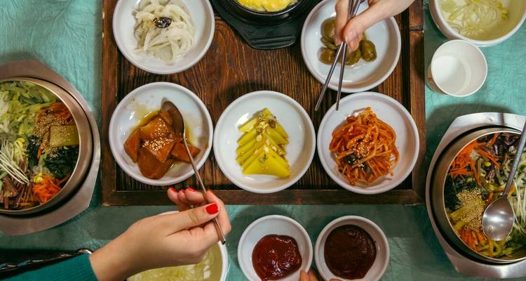 Vue plongée d'un repas coréen traditionnel avec plusieurs petits plats.
