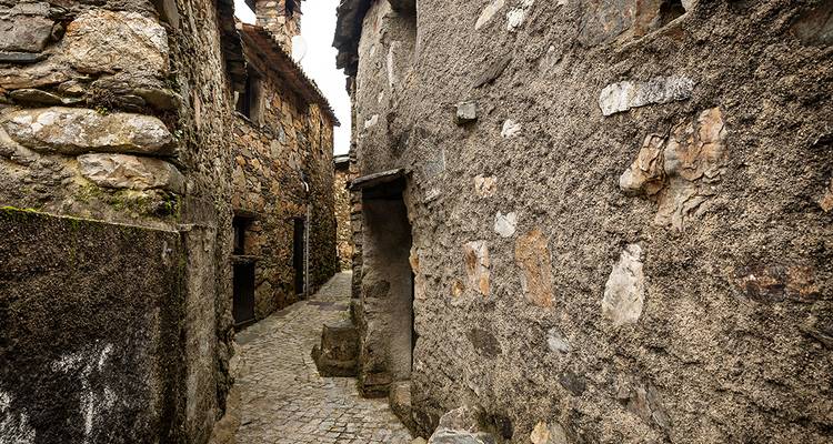 Ruelle pavée étroite avec des murs de pierre anciens.